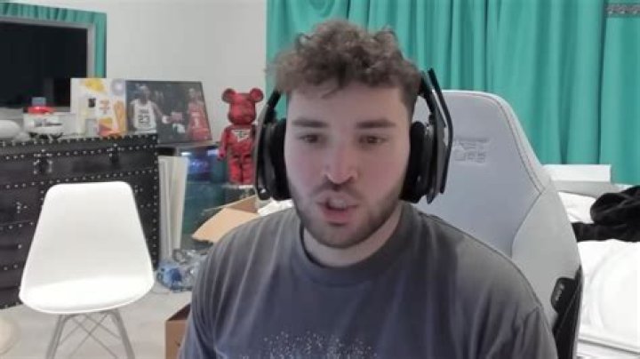 Adin Ross streaming while wearing a headset.
